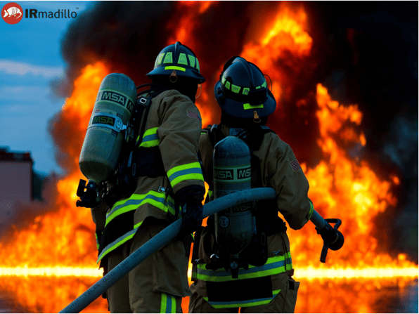 Two firefighters trying to put out a raging fire.