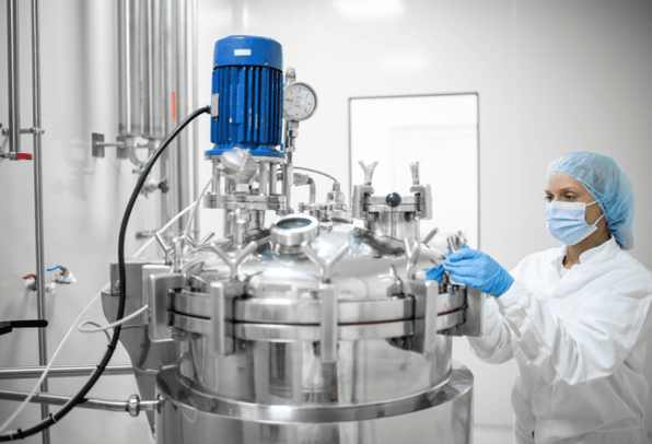 Lab technician in a pharmaceutical manufacturing plant that is fully optimised using the latest process analytical technology for real time analysis.